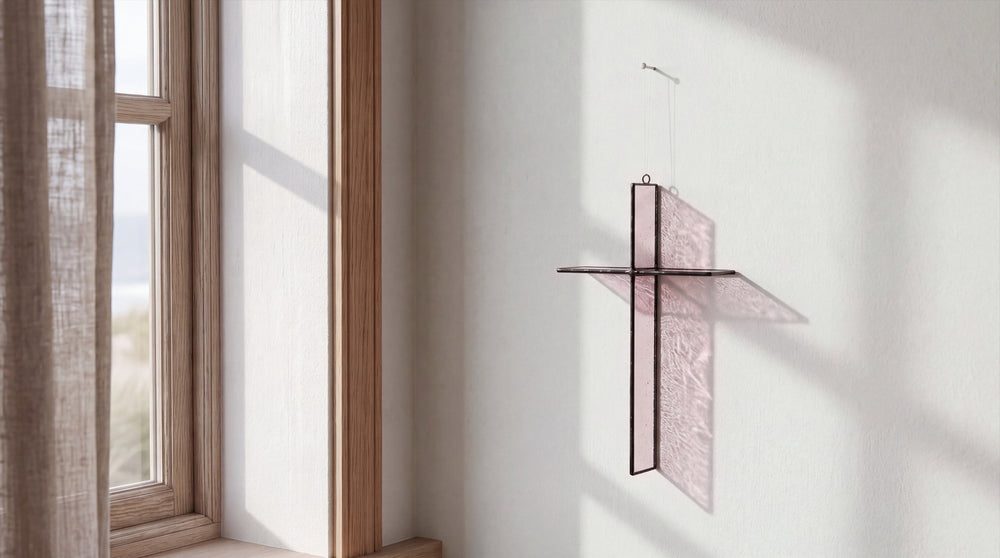 Rose Mist cross hanging on a wall beside a window
